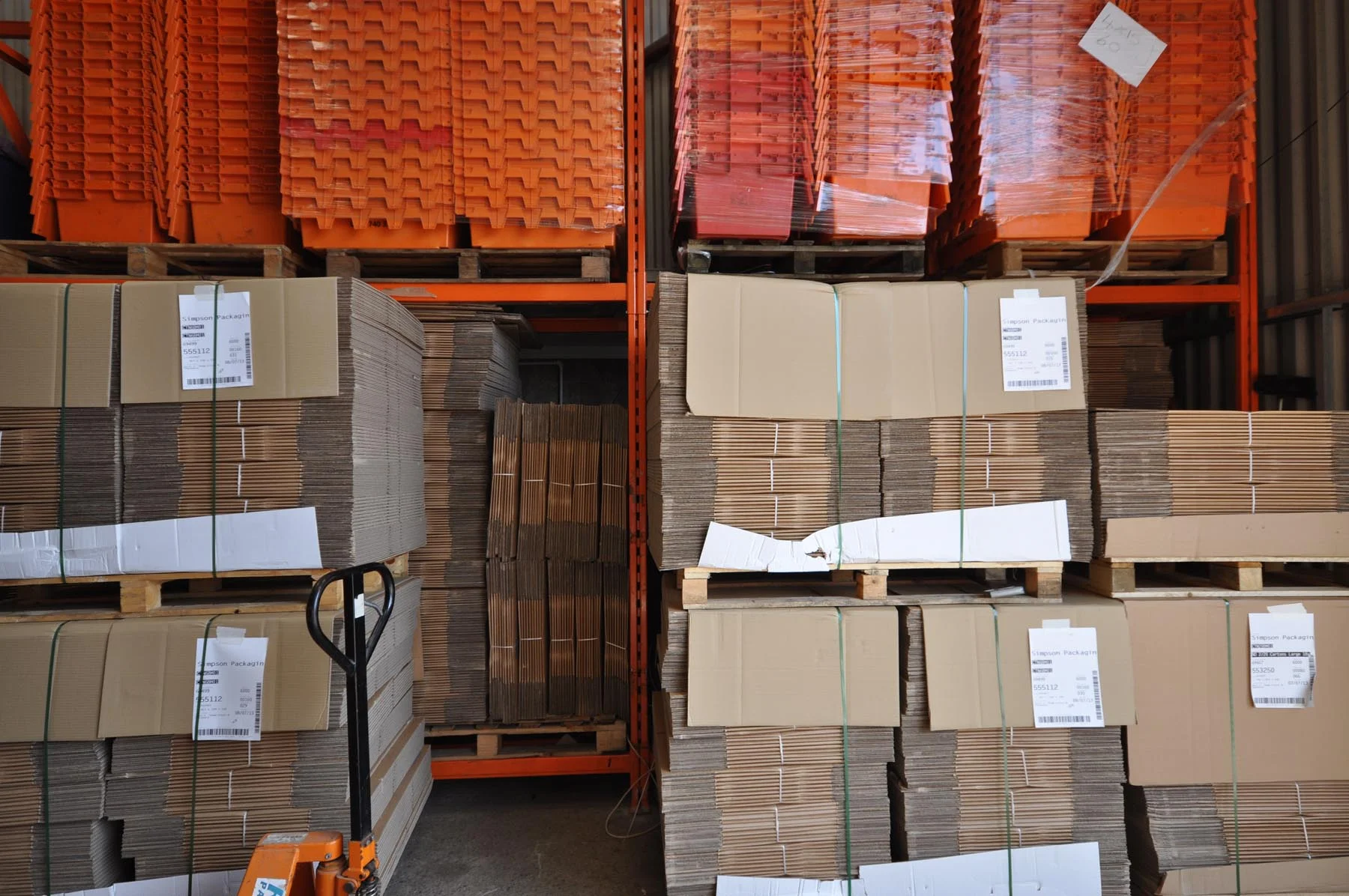 Stacks of flat-pack cartons and moving supplies in a warehouse